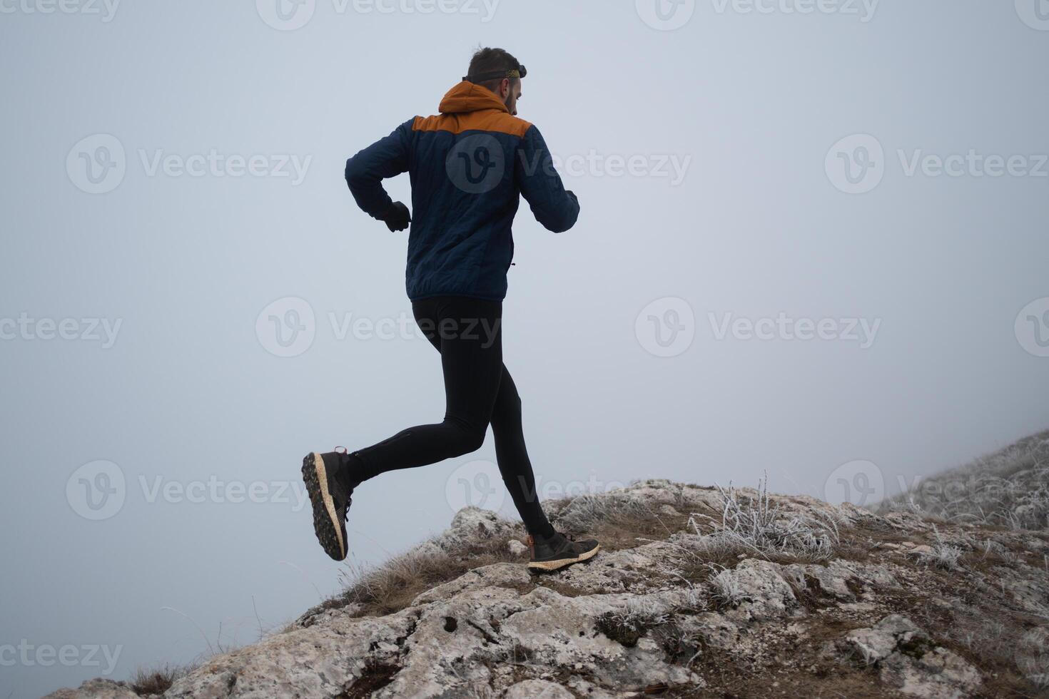 trail running man athlete prepares for ultra-marathon race in a mountain photo