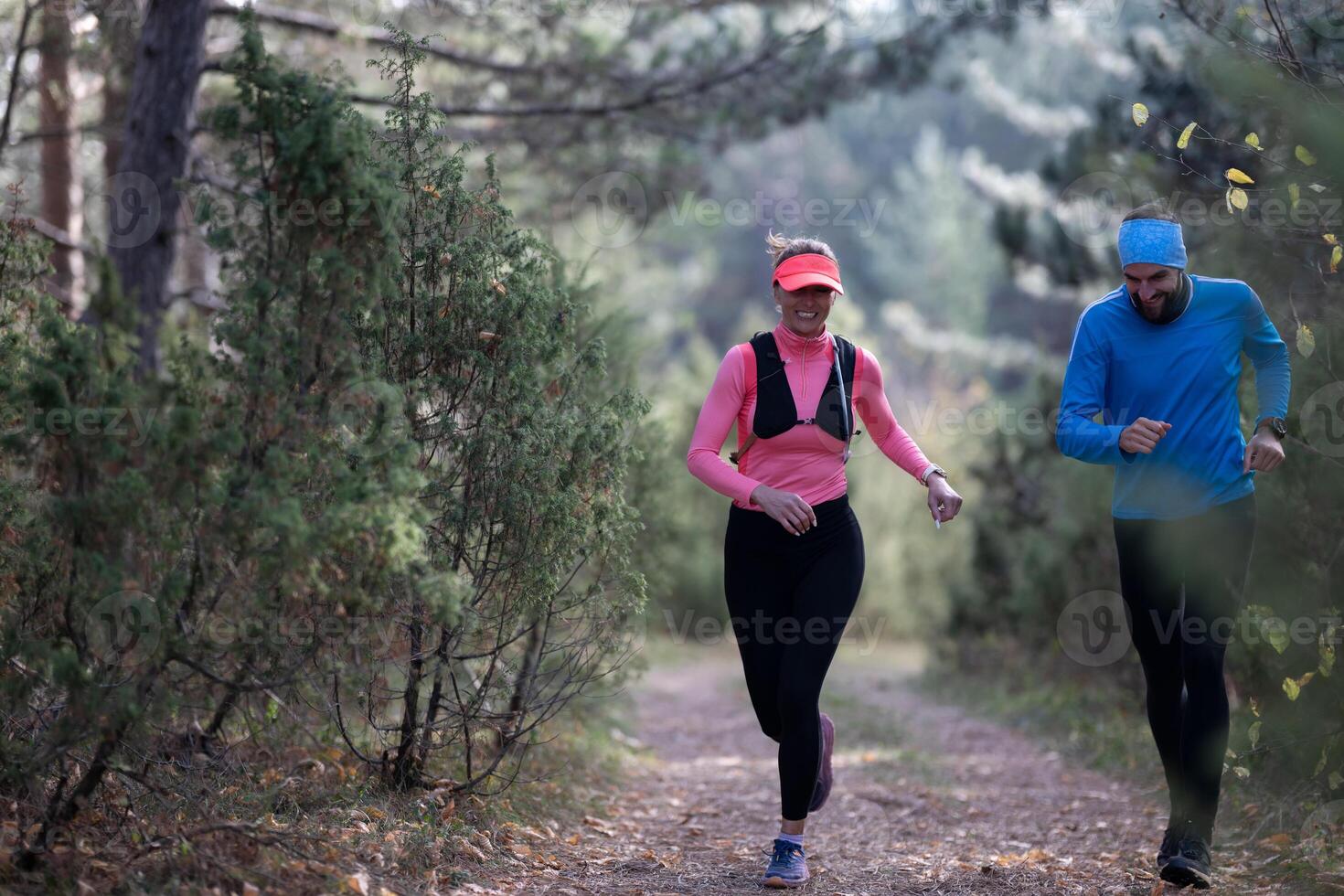 trail running with a sporty couple in the magic forest in early morning photo