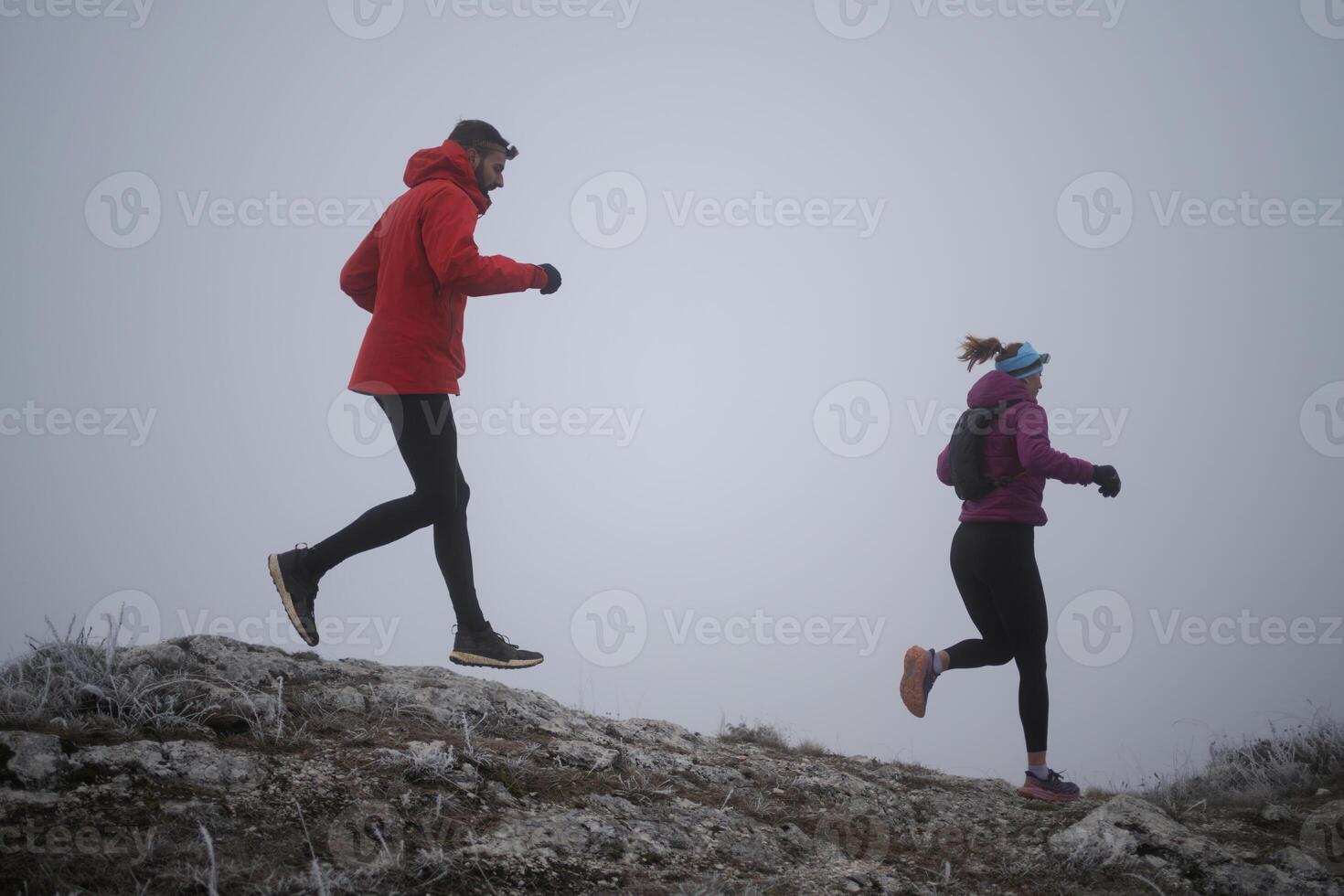 Athlete couple trail running on the mountain top in the early morning. Sky running concept photo