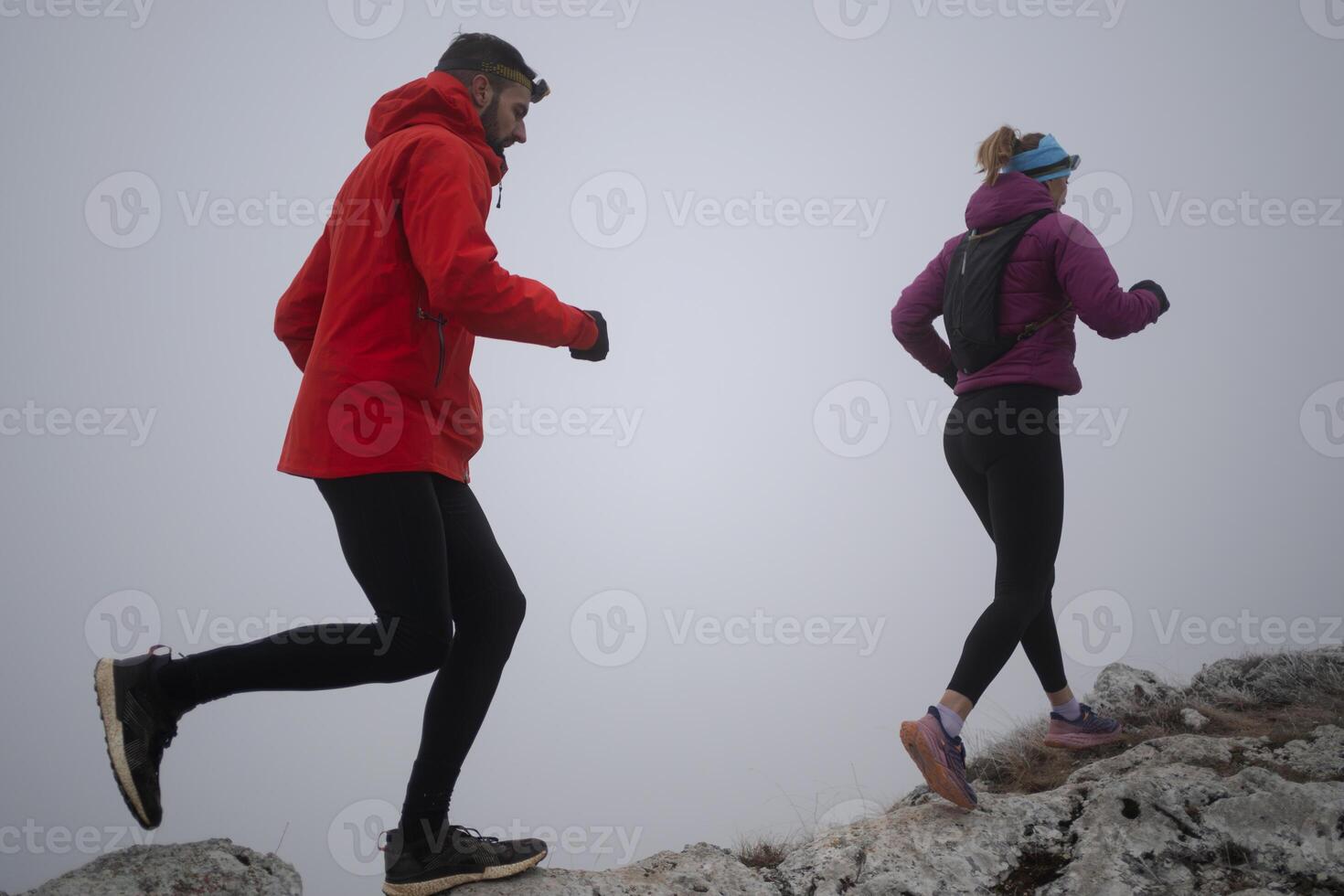 Athlete couple trail running on the mountain top in the early morning. Sky running concept photo