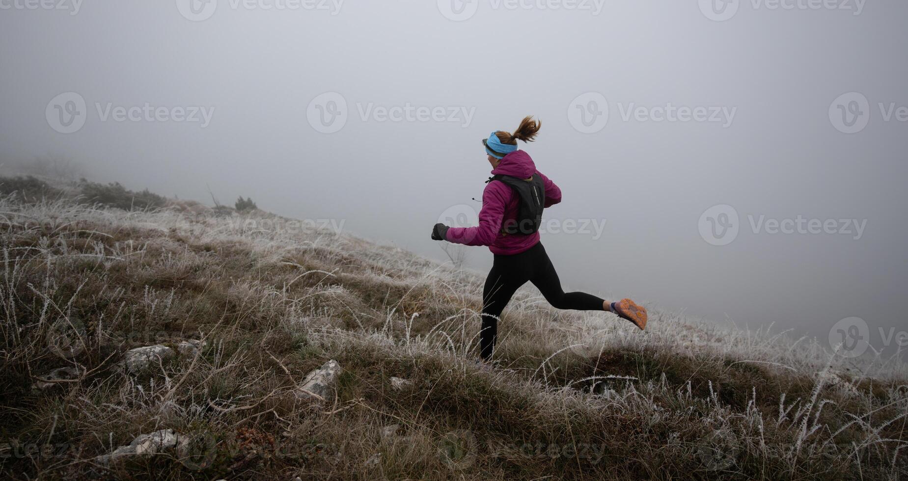 trail running woman athlete training for ultra-marathon race in a mountain photo