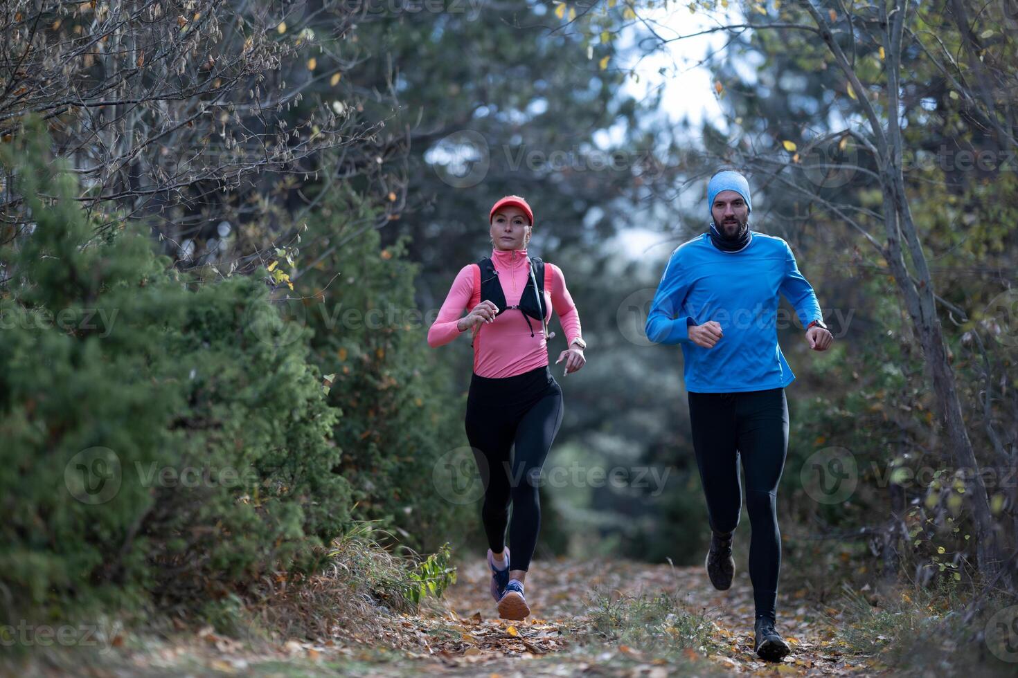 trail running with a sporty couple in the magic forest in early morning photo