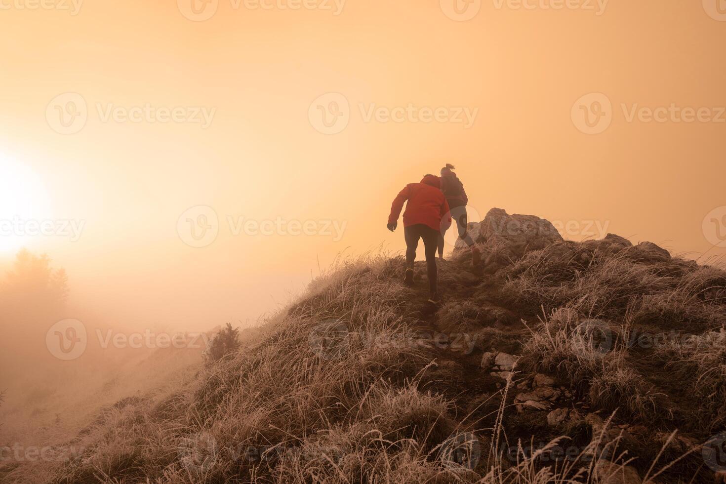 trail running couple man and woman running on a mountain path photo