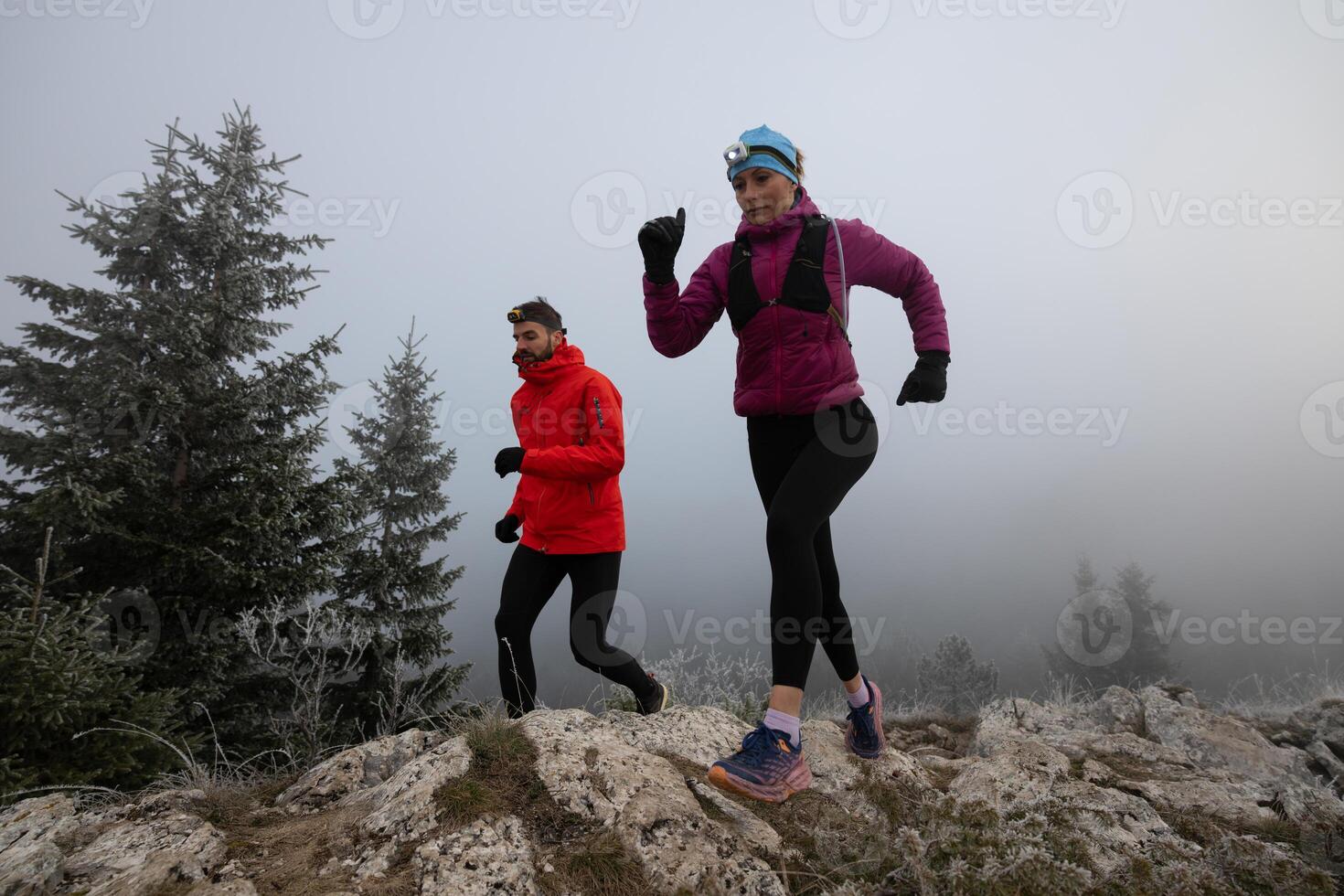 trail running couple man and woman running on a mountain path photo