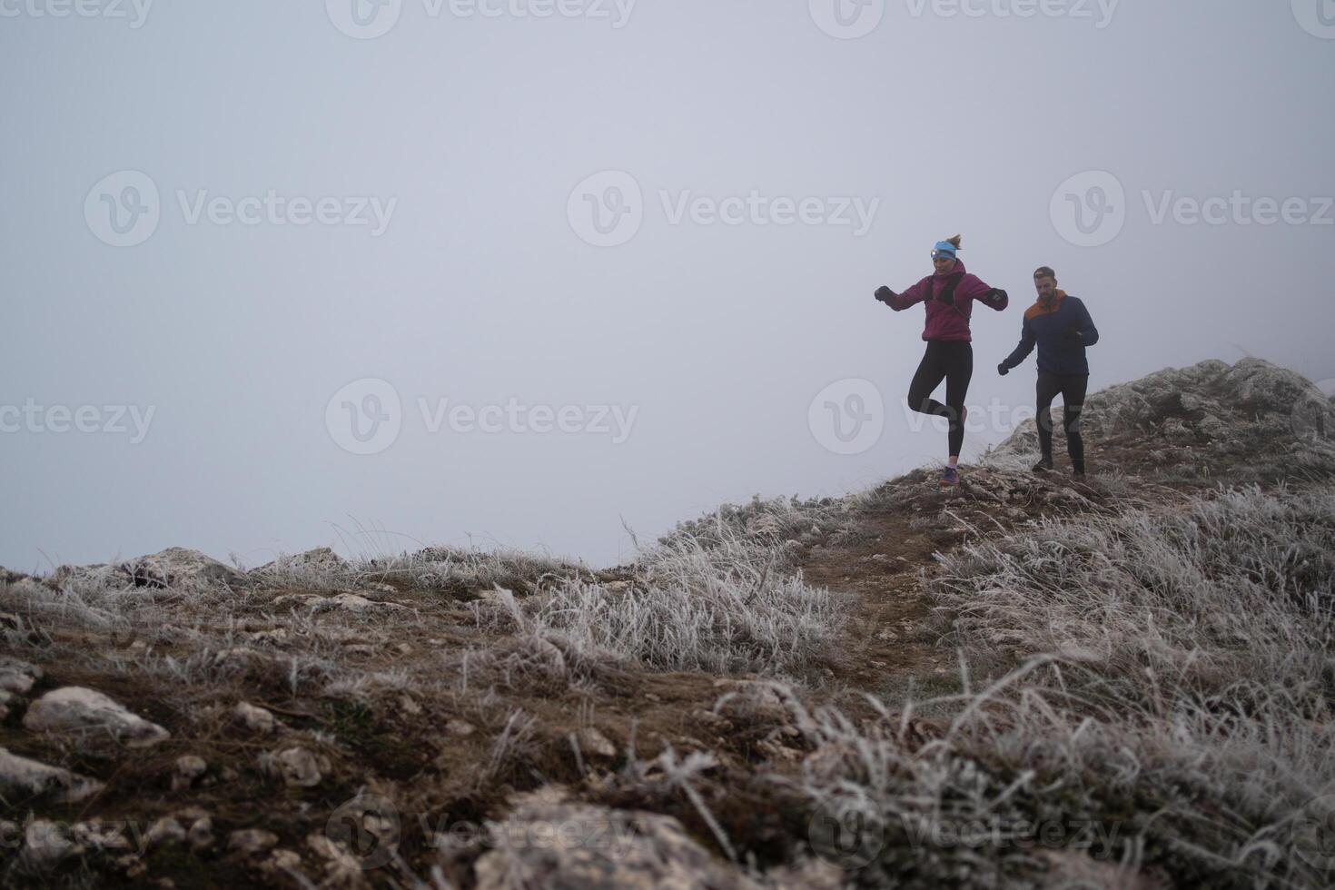 Athlete couple trail running on the mountain top in the early morning. Sky running concept photo