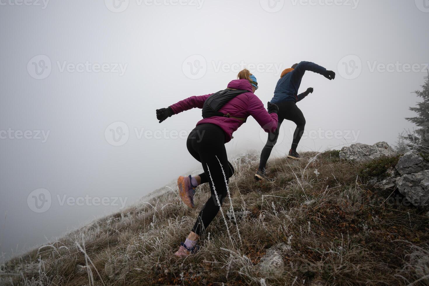 trail running couple man and woman running on a mountain path photo