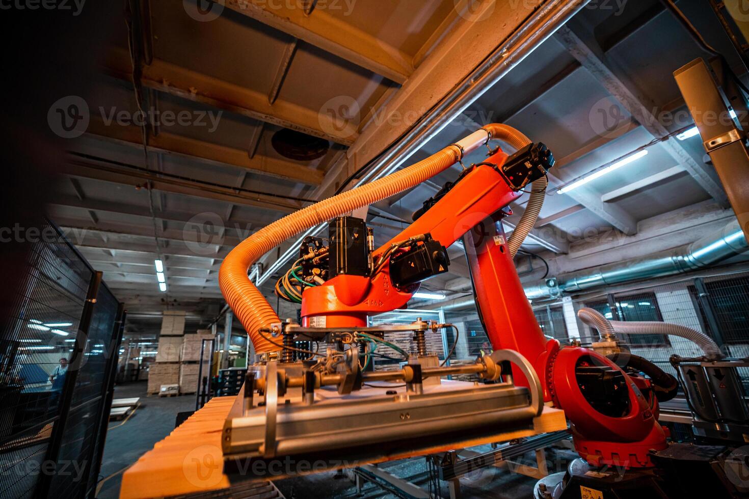A robotic arm in a woodworking factory, equipped with suction technology, lifts and processes wooden boards, highlighting automation in modern manufacturing photo