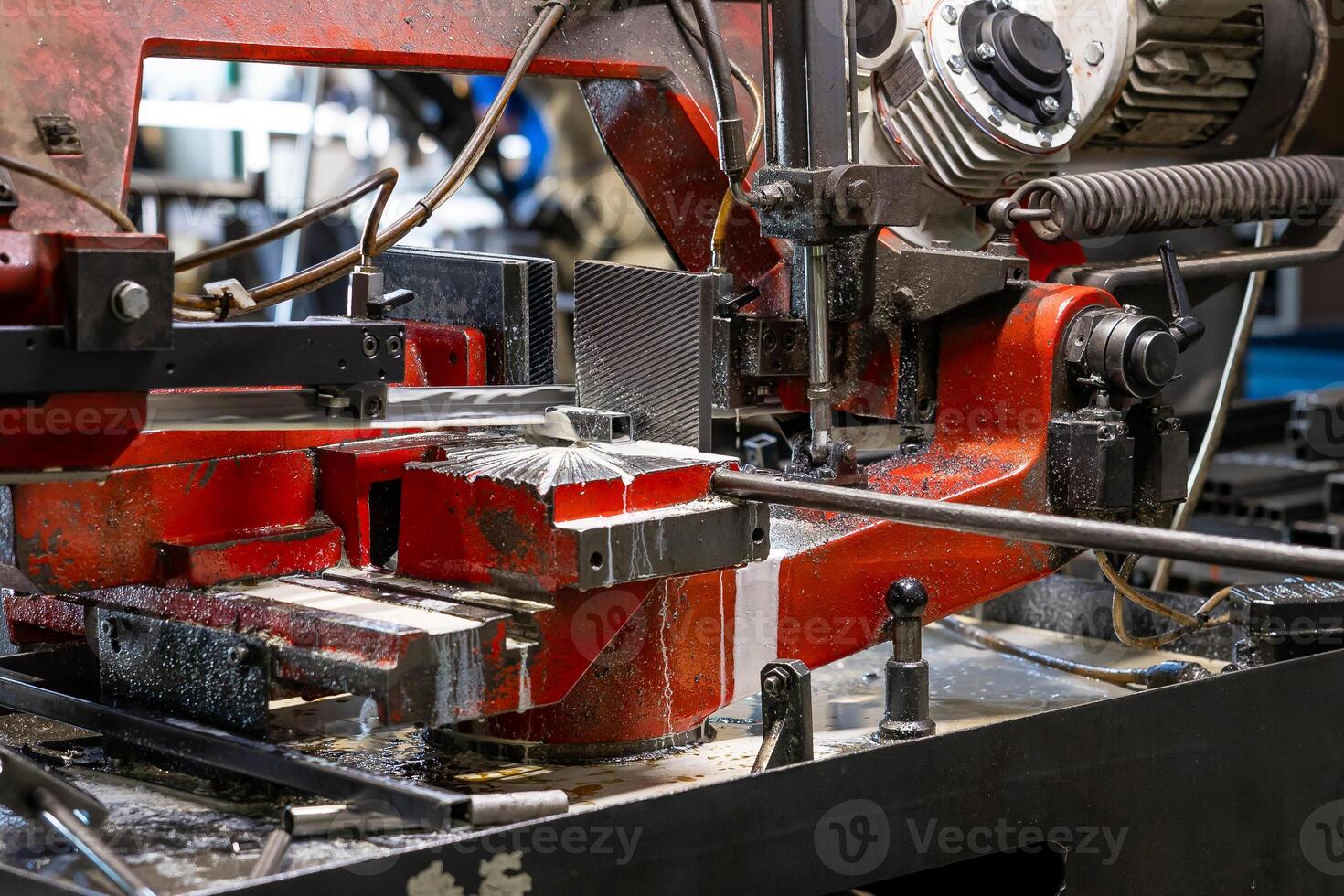 Close up of industrial cutting machinery, with visible details of the blade and surrounding equipment in a workshop setting. photo