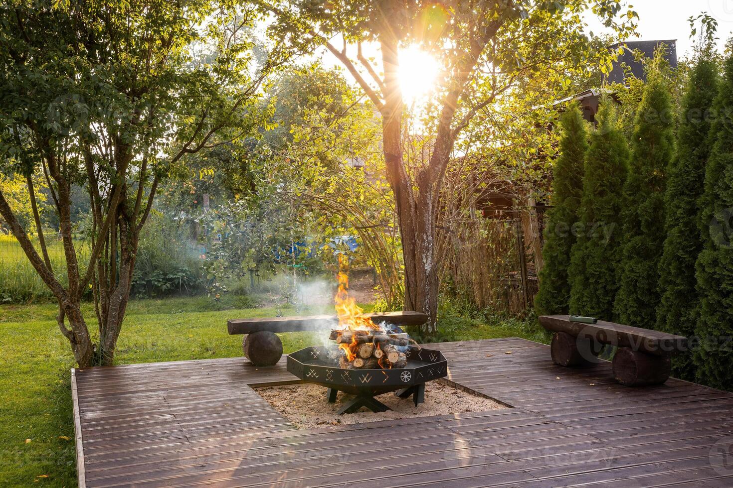 Outdoor Wooden Deck with Central Fire Pit and Rustic Benches photo