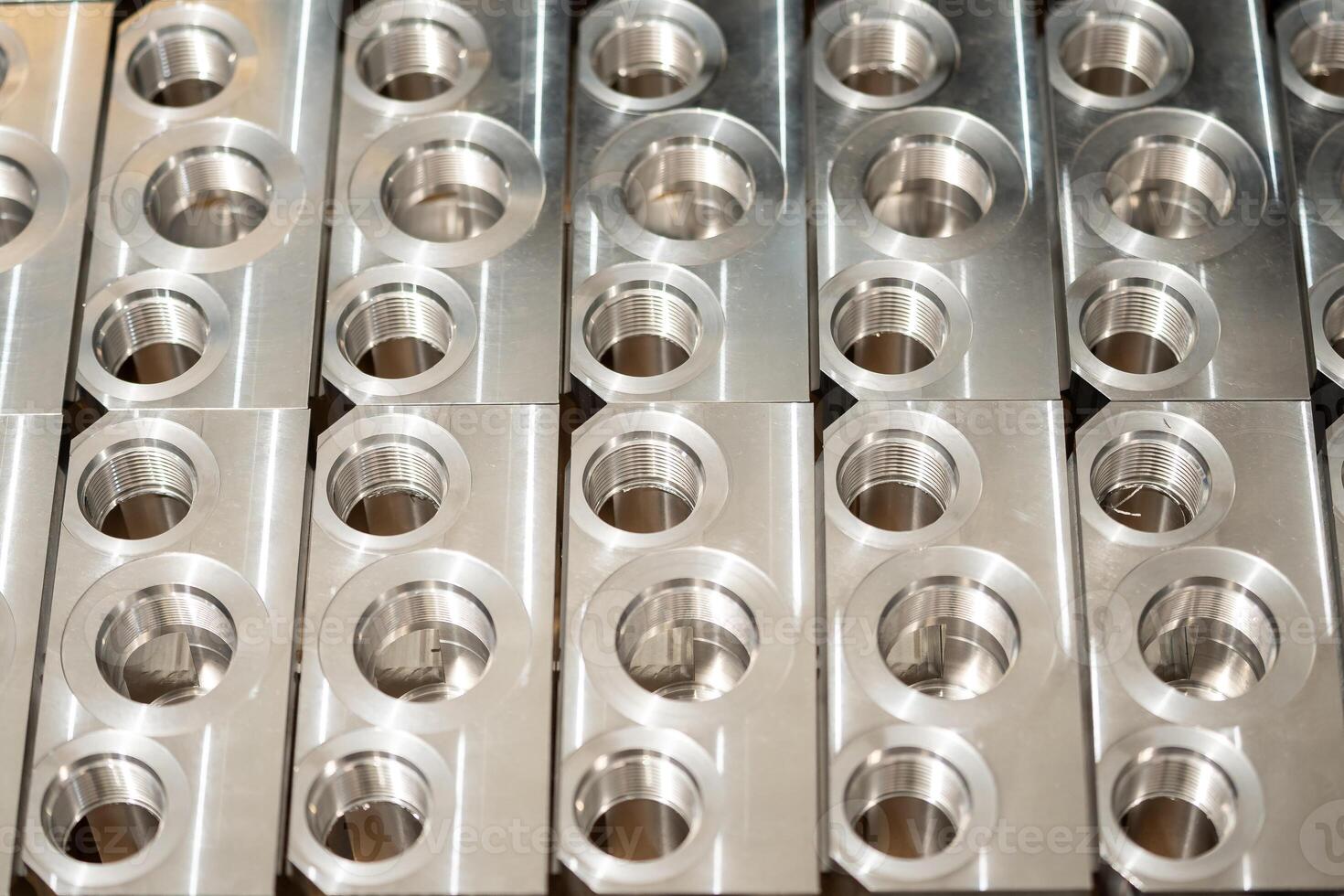 Metal components with precise threading, neatly arranged in rows, showcasing industrial precision and manufacturing quality. photo