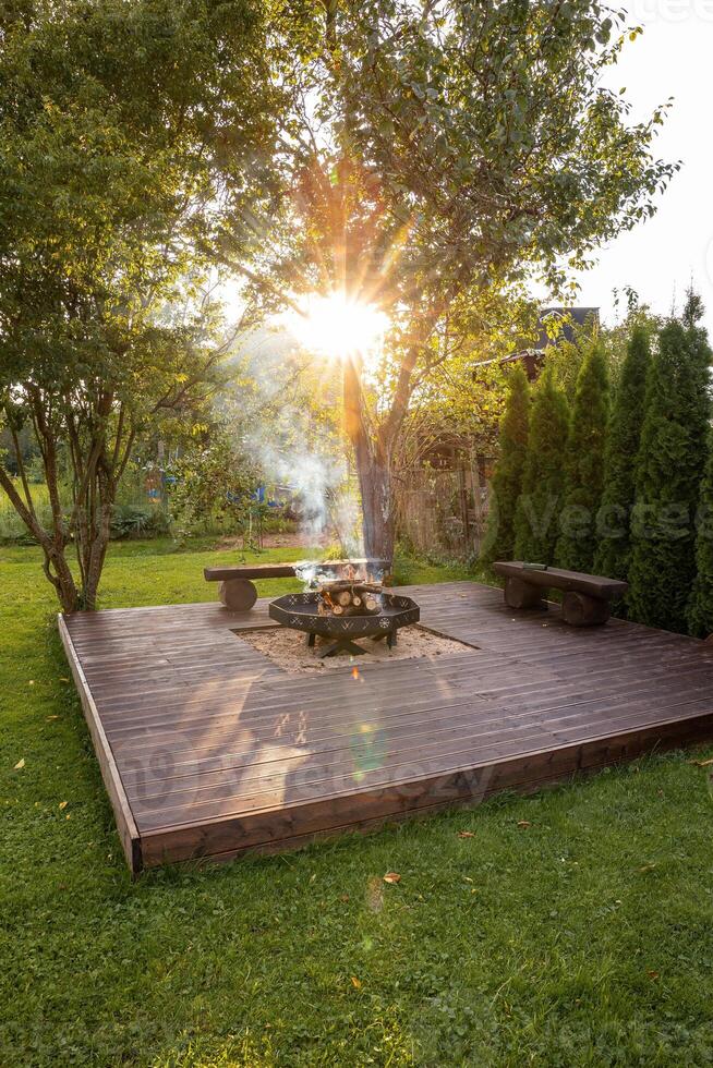 Outdoor Wooden Deck with Central Fire Pit and Rustic Benches photo