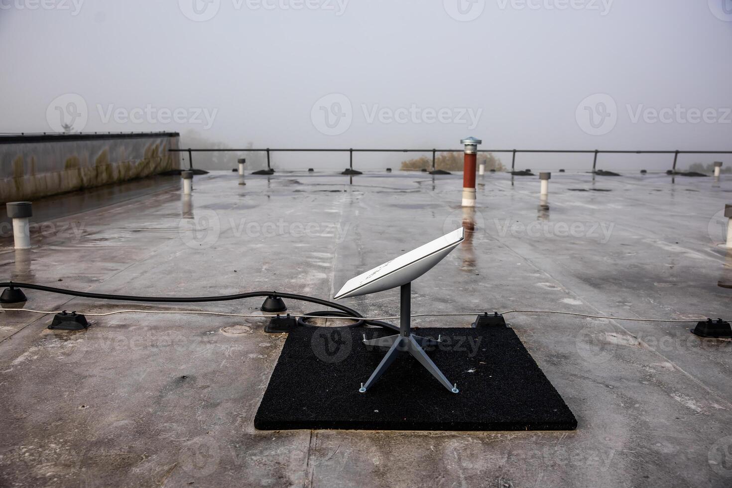 Rooftop with Satellite Dish in Foggy Industrial Setting photo