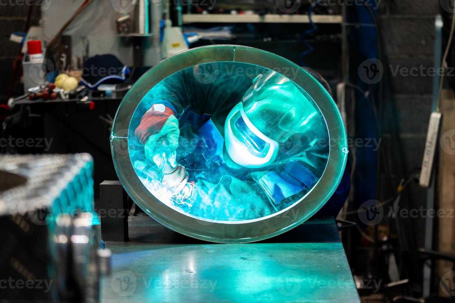 Focused welder creating strong welds on a circular metal piece, sparks flying around in the workshop. photo