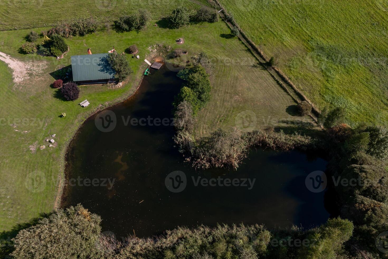 Tranquil Pond with Green Roof Building in Rural Landscape photo