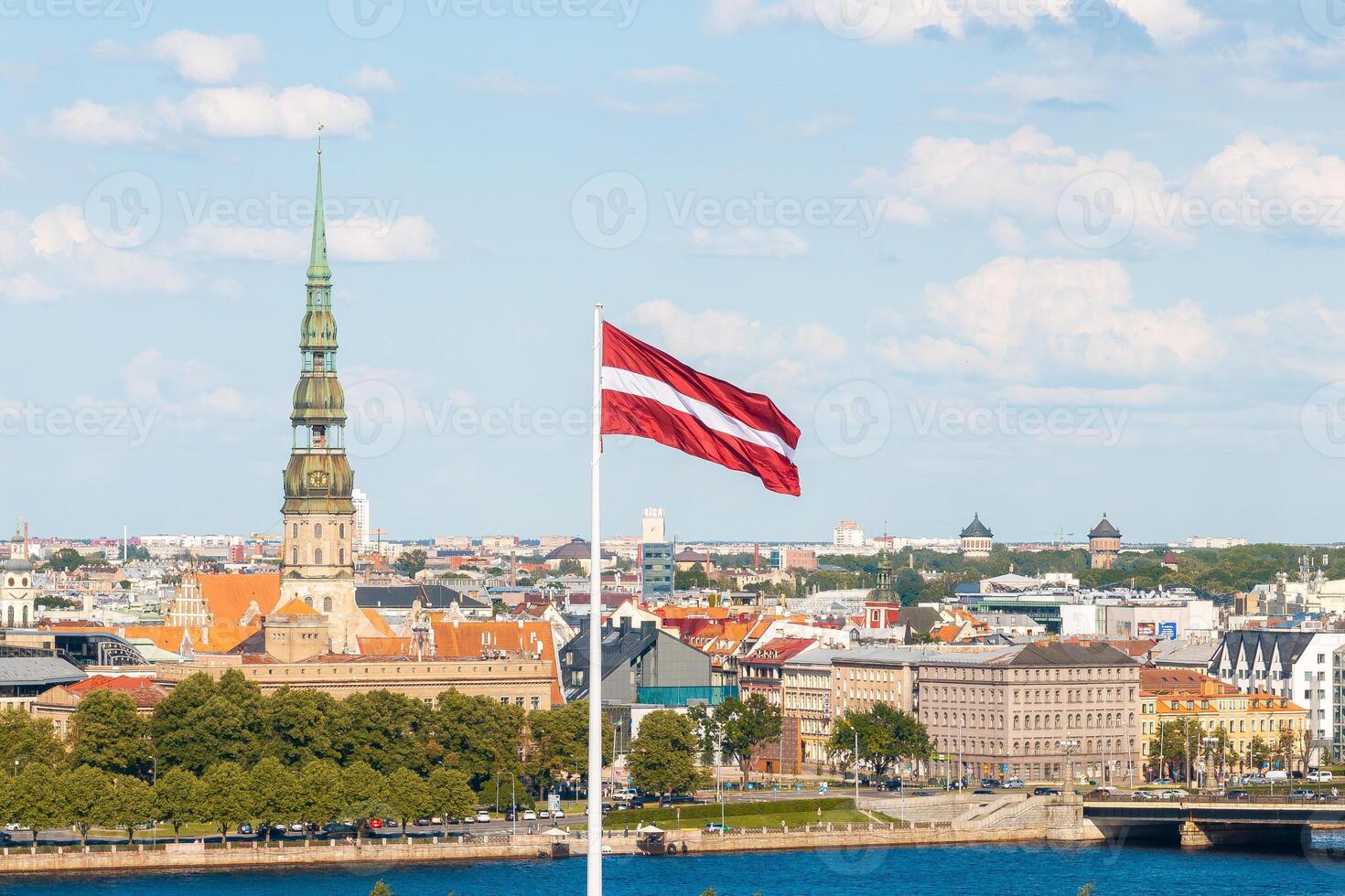 Latvian national flag waving with old Riga cityscape in the background photo