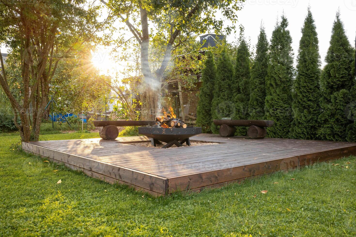 Outdoor Wooden Deck with Central Fire Pit and Rustic Benches photo