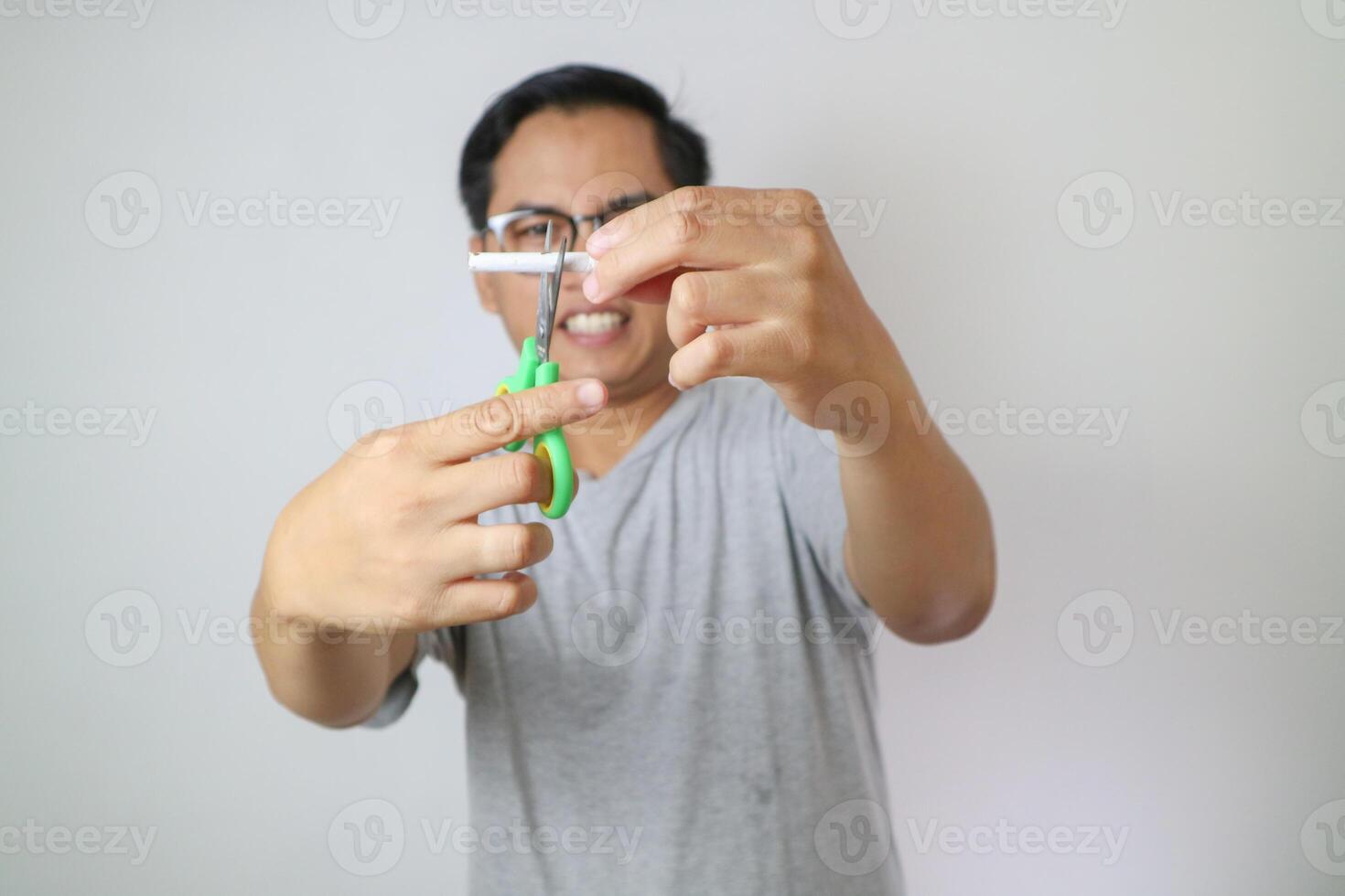 one cigarette through the blades of a scissors for kids. white and blue color scissors for child's activities. stop smoking concept. take down national day of action. world no tobacco day. free space photo