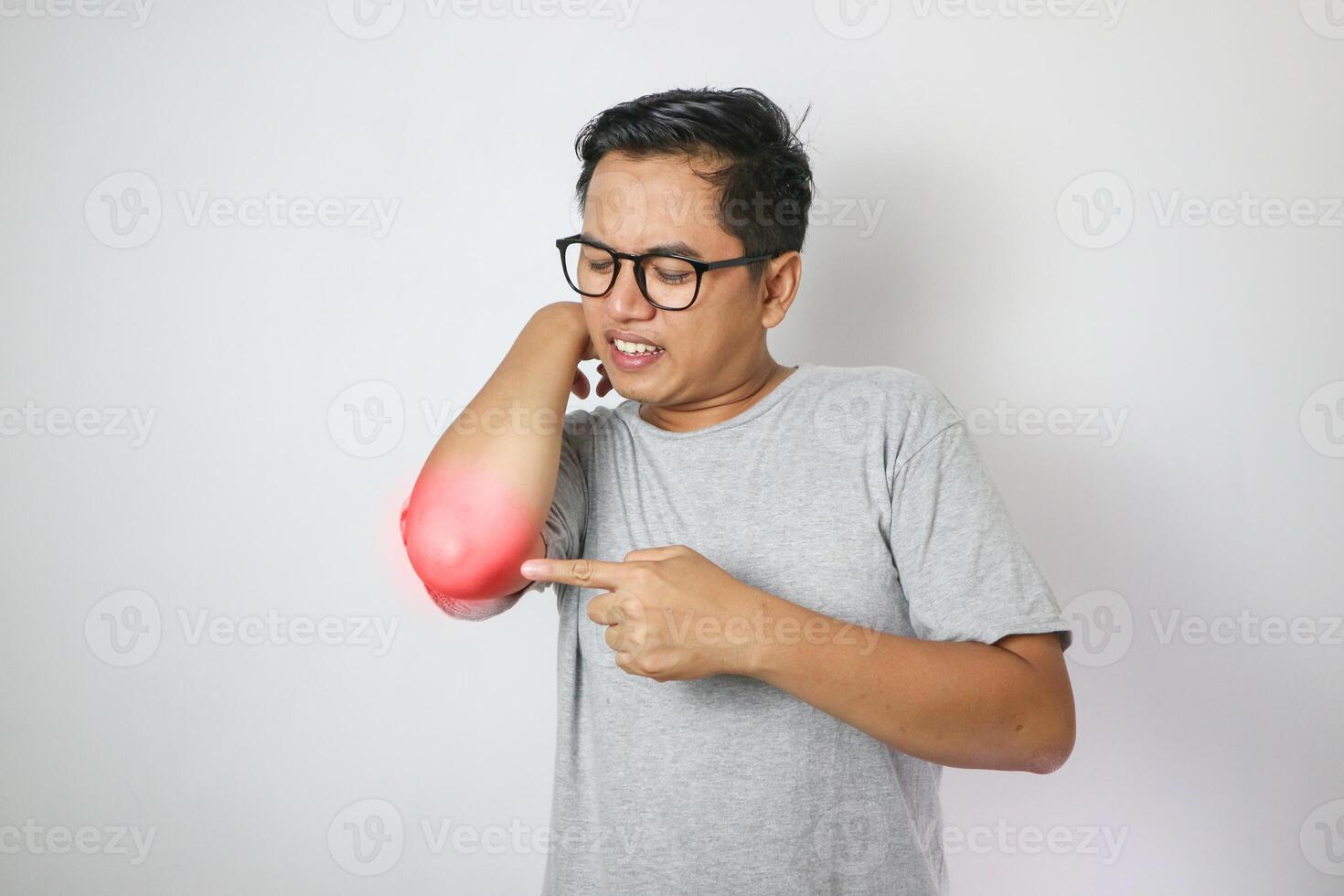 Person with elbow pain, concept of a people with elbow pain from rheumatism, shirtless man massaging sore elbow, man with elbow cramp. photo