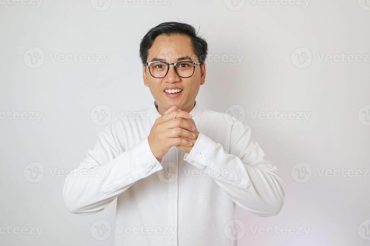 Smile face of Asian man wearing Chinese traditional cloth called Cheongsam with a gesture of congratulations on the Lunar New Year and looking at the camera on white background. Gong Xi Fa Cai photo