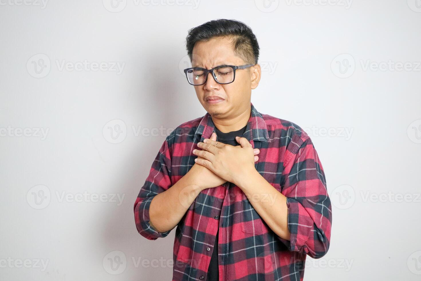 hand hold chest with heart attack symptoms, asian man working hard have chest pain caused by heart disease, leak, dilatation, enlarged coronary heart, press on the chest with a painful expression photo