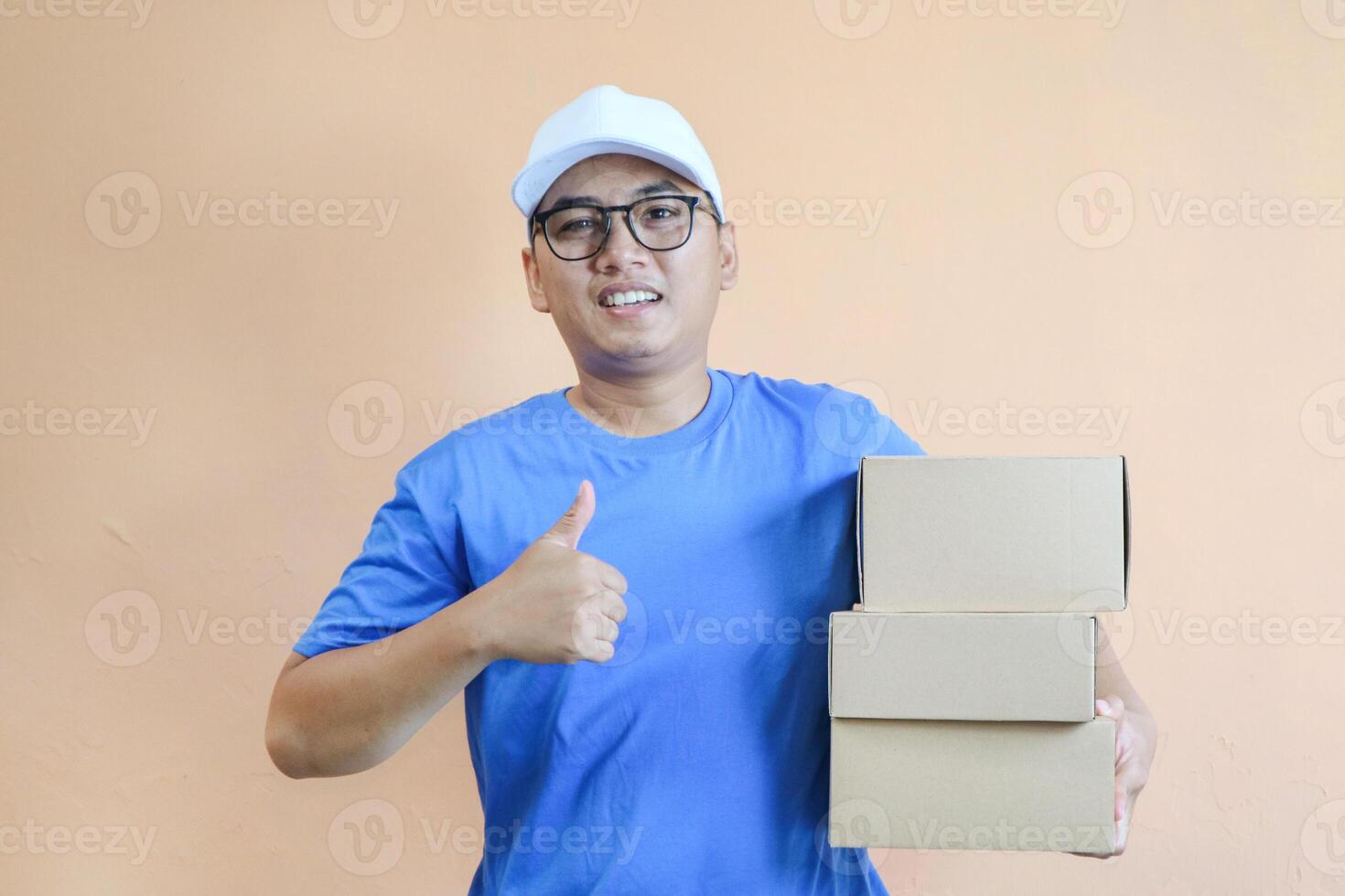 delivery man thumbs up isolated on orange with clipping path. photo