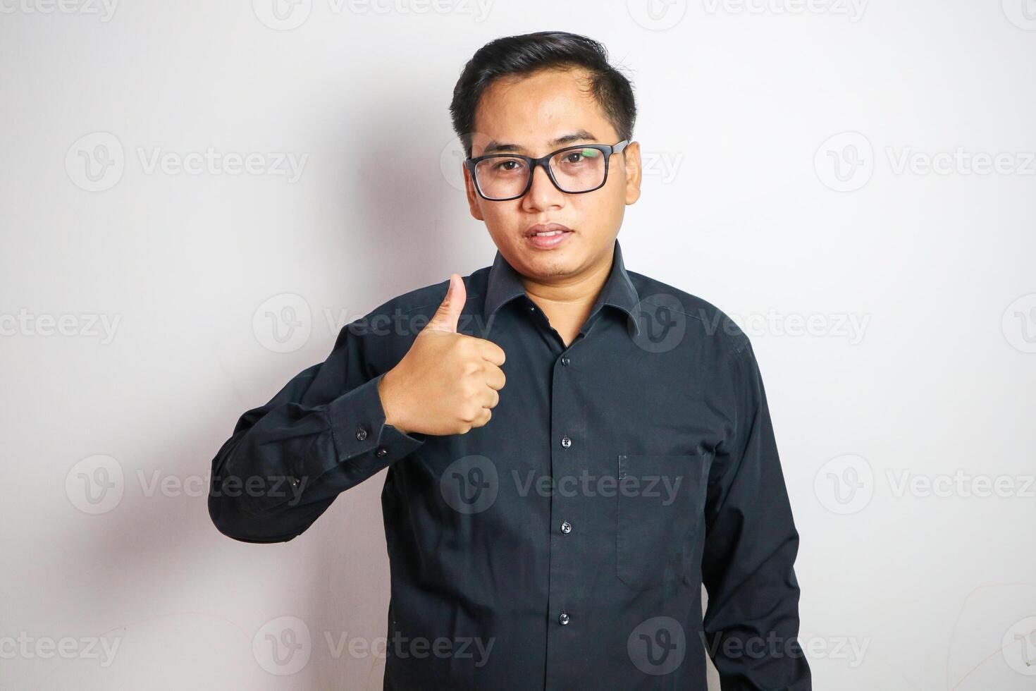 Young Asian businessman in suit showing thumbs up isolated on white background photo