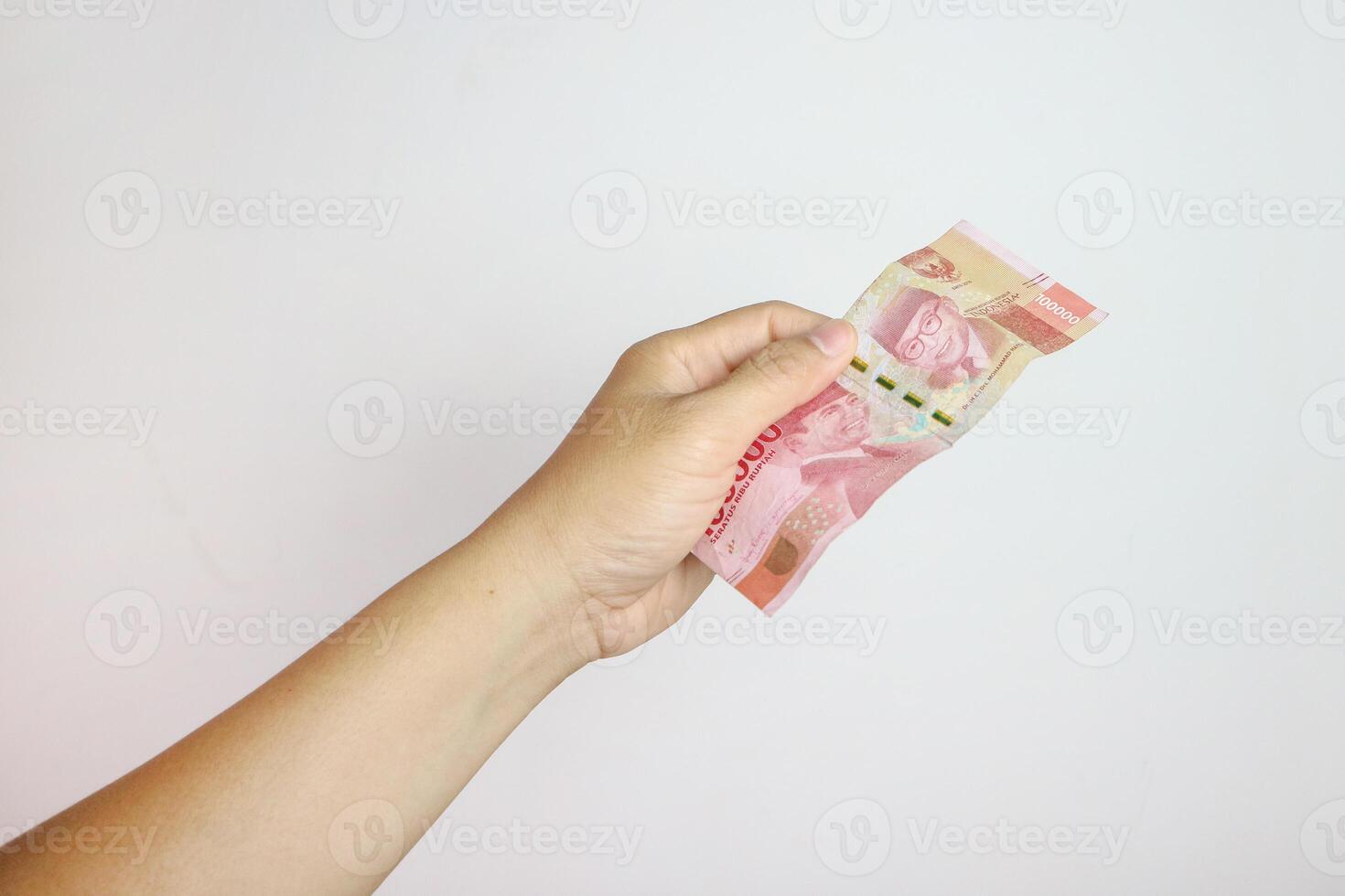 Man's Hand holding rupiah money isolates on white background photo