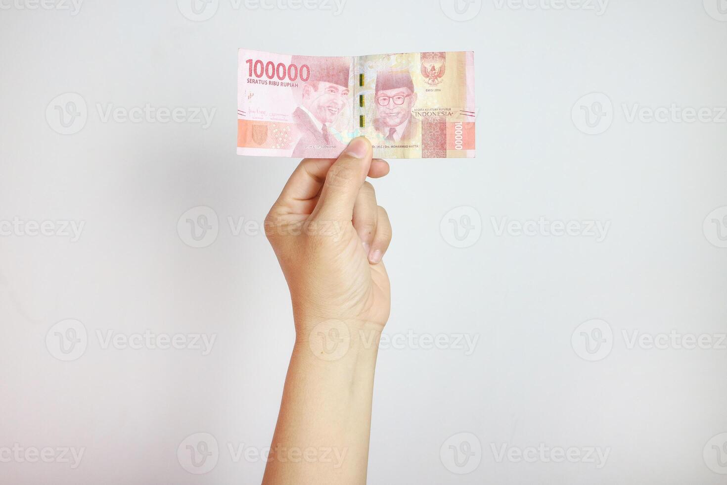 male hand holding new rupiah banknote in 2022. new 100,000 or hundred thousand rupiah denomination isolated on white background photo