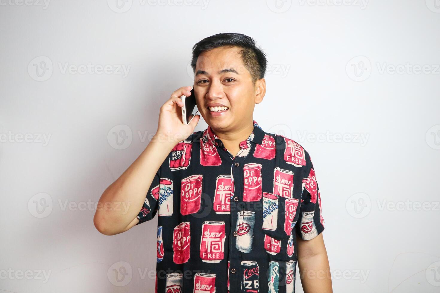 Asian young man backpacker talking on phone while walking in the city. Handsome male tourist traveler traveling alone on street, using smartphone, enjoy spending free time on holiday vacation trip. photo