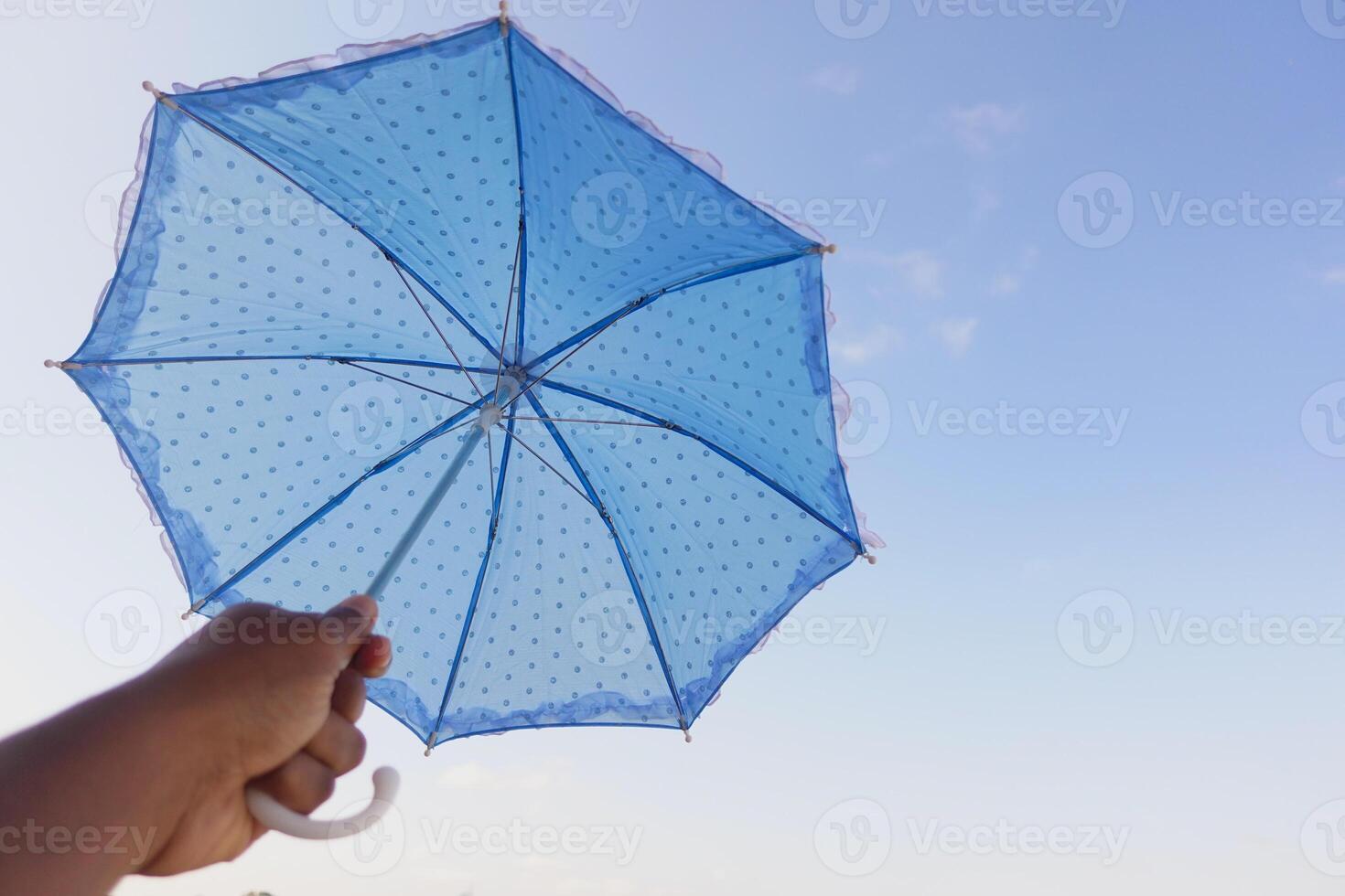 A Bright Blue Polka Dot Umbrella Set Against a Beautifully Clear and Clear Sky Above, Glowing photo
