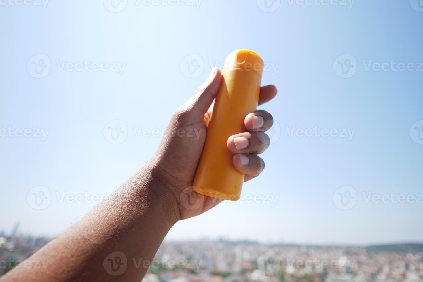 Close up of person hand using sunscreen cream outdoor photo