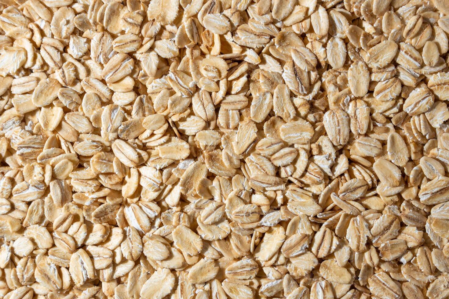 Uncooked Oat Flakes background - Top View, Flat Lay. Scattered Dry and Raw Oat Flakes. Healthy Breakfast and Diet Eating Ingredients photo