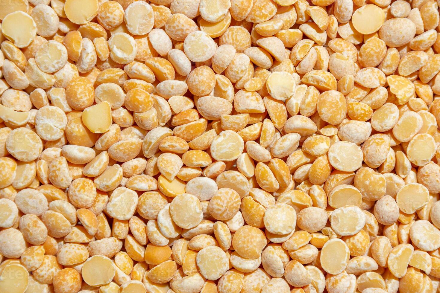 Uncooked Polished Split Peas Background. A Culinary Canvas of Dry Yellow Peas, Creating a Lively and Textured Background for Gourmet Cooking. Scattered Raw Polished Peas. Healthy Eating Ingredients photo