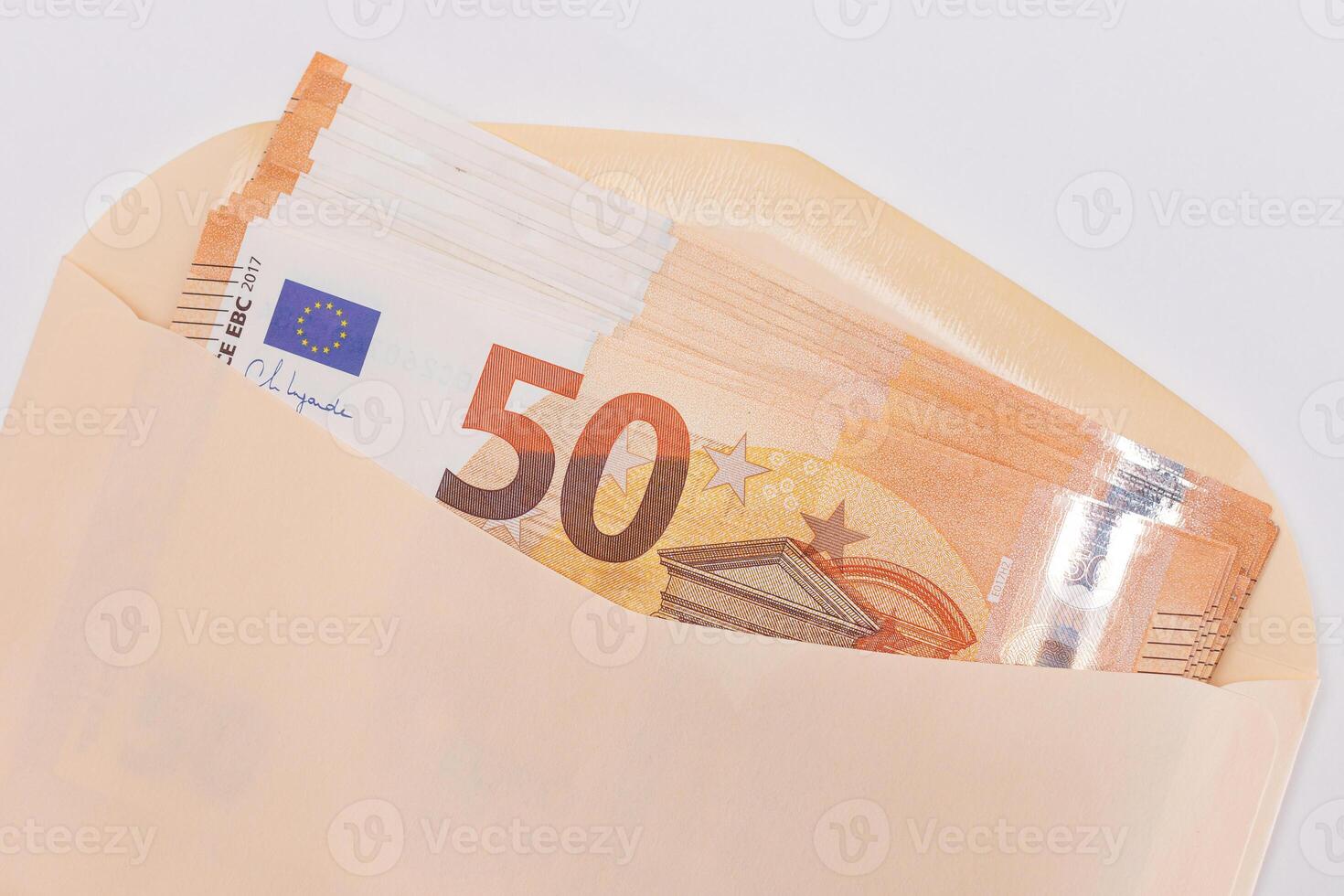 An Orange Paper Envelope with Stack of 50-Euro Banknotes Inside. Salary in Cash. Tax-Free System. Euro Currency. Payments with No Taxes. Orange Paper Money. A Lot of Fifty-Euro Bills photo