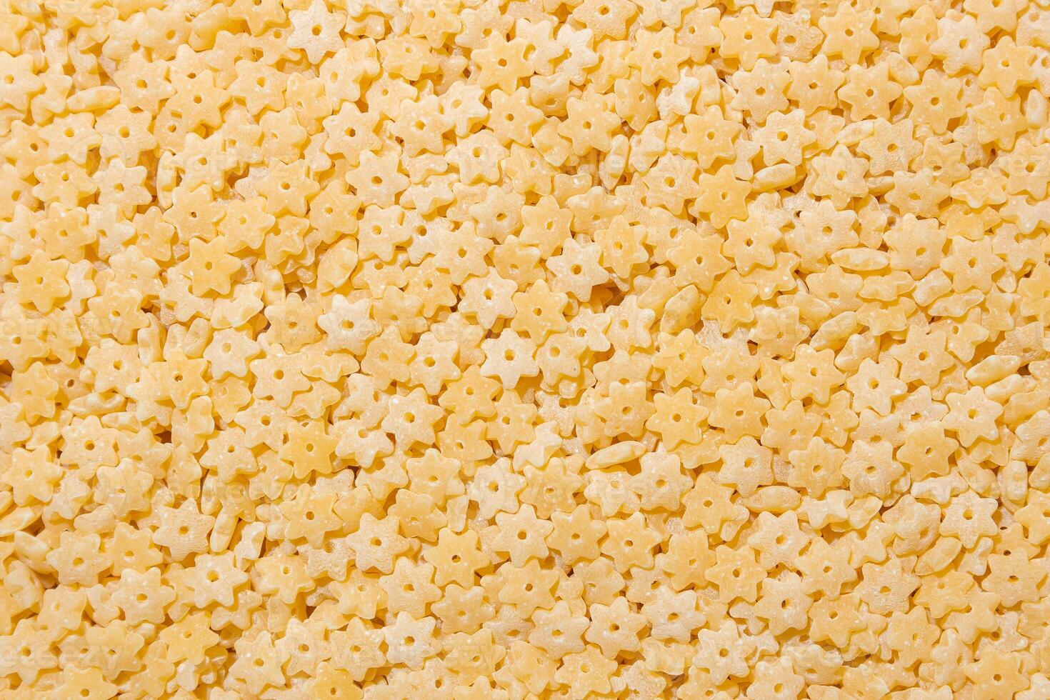 Uncooked Stelline Pasta. A Culinary Canvas of Stelline Macaroni, Creating a Lively and Textured Background for Gourmet Cooking. Dry Pasta. Raw Macaroni - Top View, Flat Lay photo
