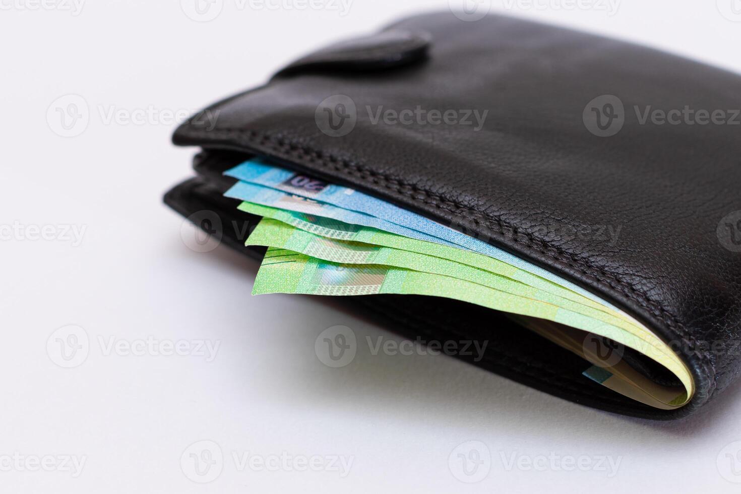 Black Leather Men Wallet with Euro Banknotes Inside on White Background. A Purse Full of Money Symbolizing Wealth, Success and Social Status photo