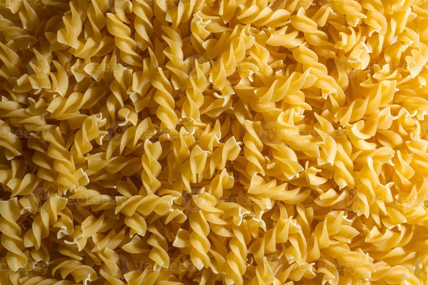 Uncooked Fusilli Pasta. A Culinary Canvas of Spiral Macaroni, Creating a Lively and Textured Background for Gourmet Cooking. Dry Pasta. Raw Macaroni - Top View, Flat Lay photo