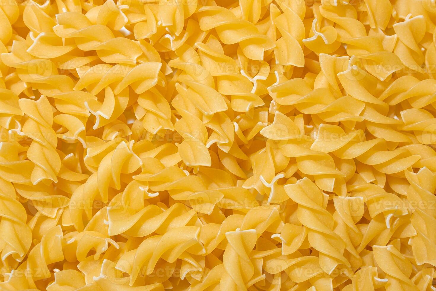 Uncooked Fusilli Pasta. A Culinary Canvas of Spiral Macaroni, Creating a Lively and Textured Background for Gourmet Cooking. Dry Pasta. Raw Macaroni - Top View, Flat Lay photo