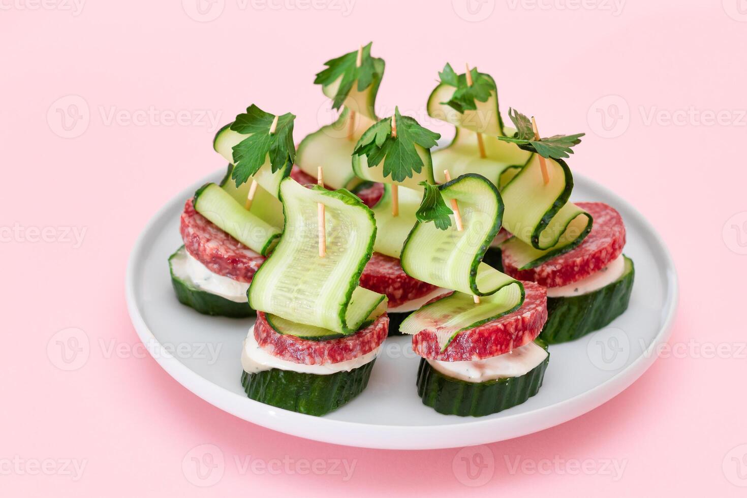 Canapes without Bread with Salami, Cucumber, Greens and Cream Cheese on White Plate. Easy Breakfast. Diet Food. Quick and Healthy Sandwiches. Healthy Snacks with Tasty Fillings photo