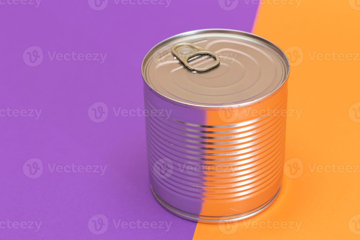 Unopened Tin Can on Split Orange and Violet Background. Canned Food. Aluminum Can for Safe and Long Term Storage of Food. Steel Sealed Food Storage Container photo