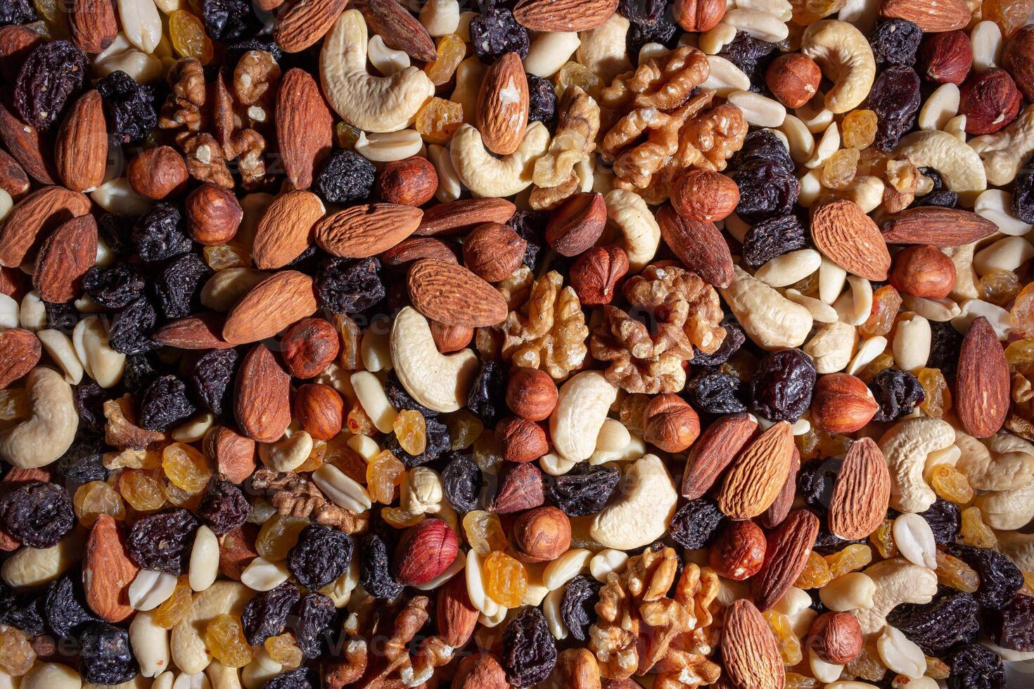 Mixed Nuts. Almonds, Walnuts, Cashews, Peanuts, Hazelnuts, Dried Prunes and Raisins. Different Nut Mix. Background from Various Nuts and Dried Fruits photo