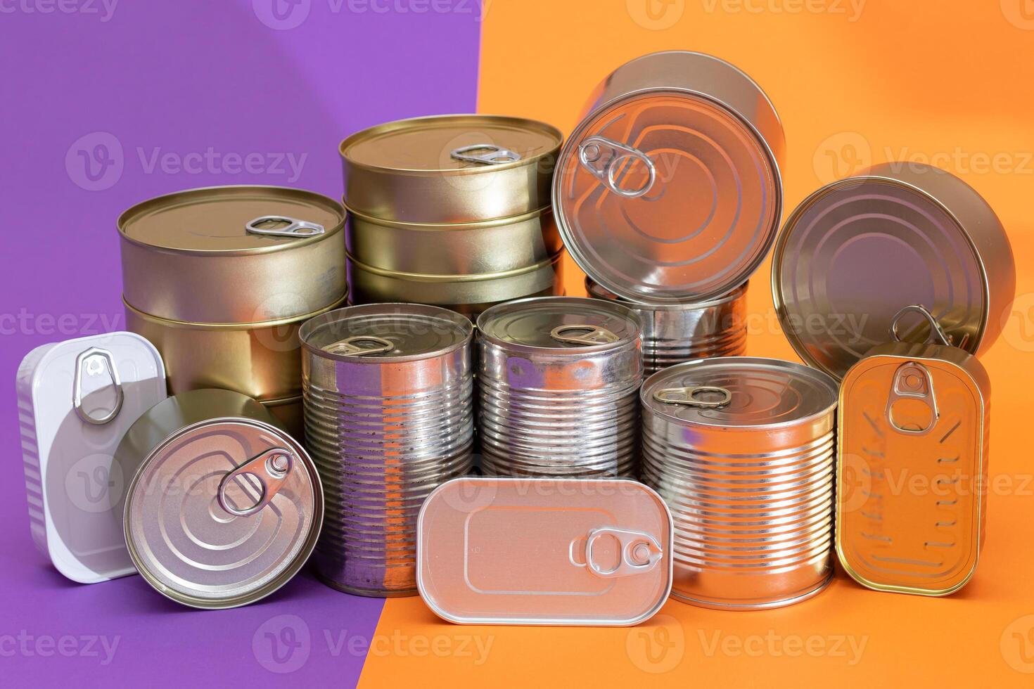 A Group of Stacked Tin Cans with Blank Edges on Split Orange and Violet Background. Canned Food. Different Aluminum Cans for Safe and Long Term Storage of Food. Steel Sealed Food Storage Containers photo
