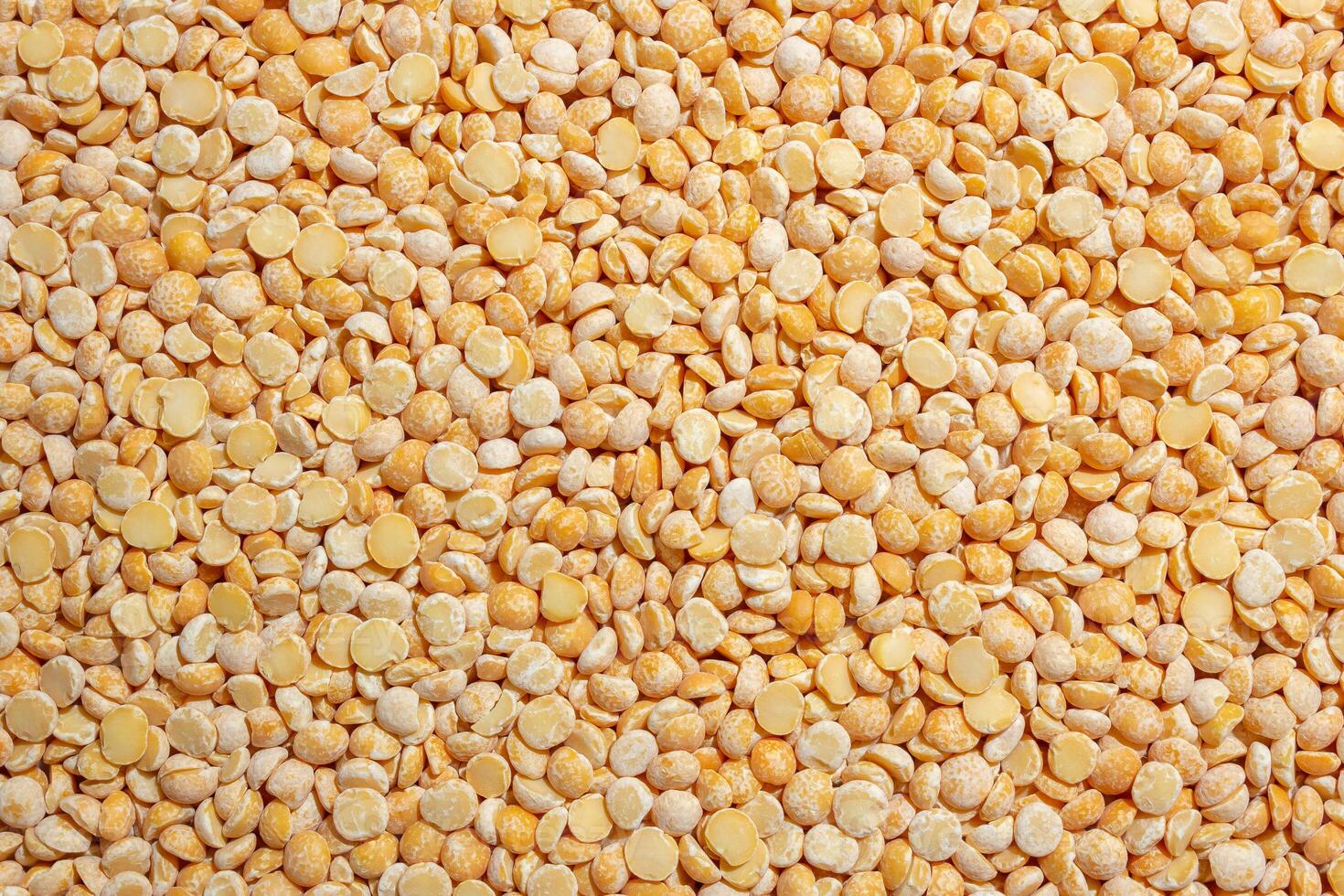 Uncooked Polished Split Peas Background. A Culinary Canvas of Dry Yellow Peas, Creating a Lively and Textured Background for Gourmet Cooking. Scattered Raw Polished Peas. Healthy Eating Ingredients photo