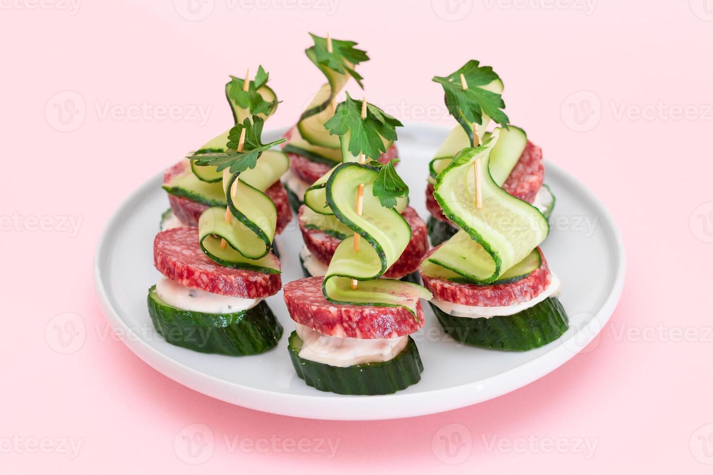 Canapes without Bread with Salami, Cucumber, Greens and Cream Cheese on White Plate. Easy Breakfast. Diet Food. Quick and Healthy Sandwiches. Healthy Snacks with Tasty Fillings photo