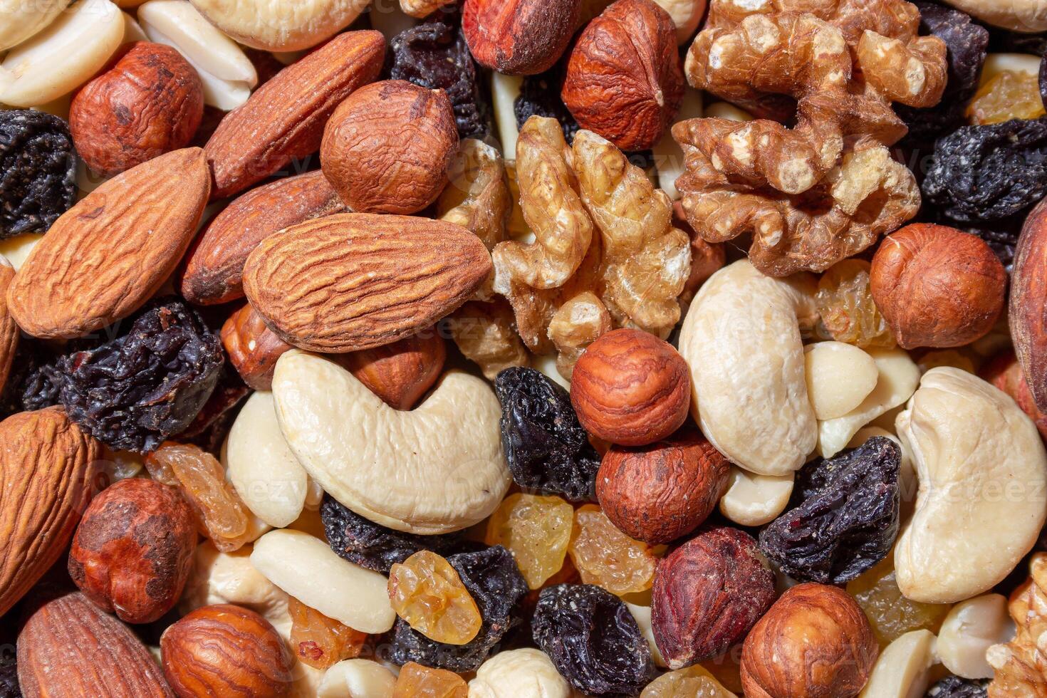 Mixed Nuts. Almonds, Walnuts, Cashews, Peanuts, Hazelnuts, Dried Prunes and Raisins. Different Nut Mix. Background from Various Nuts and Dried Fruits photo