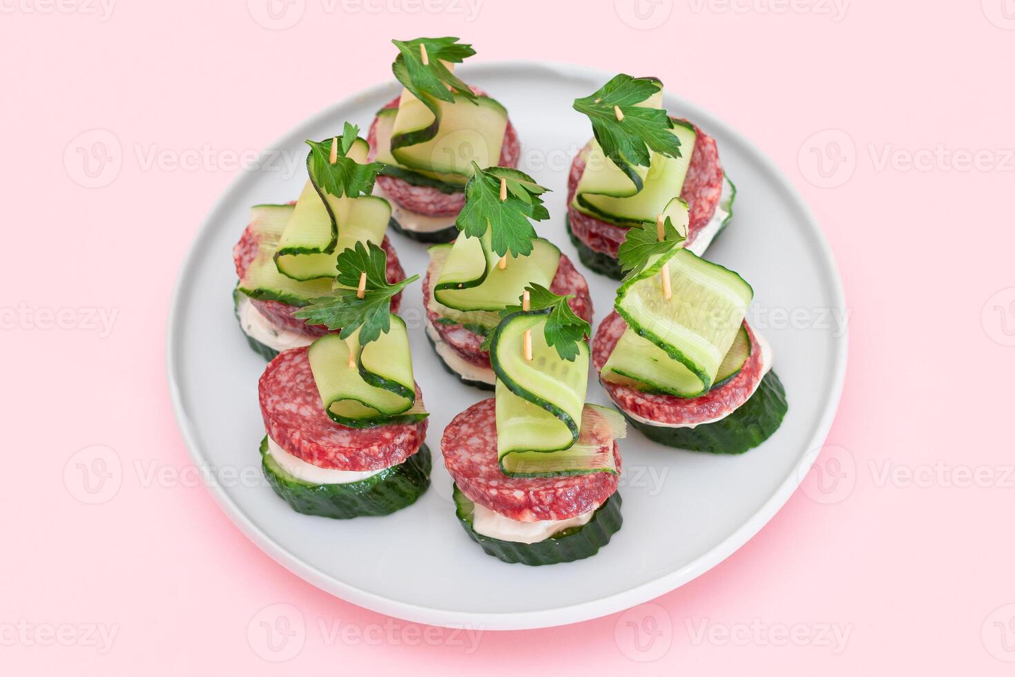 Canapes without Bread with Salami, Cucumber, Greens and Cream Cheese on White Plate. Easy Breakfast. Diet Food. Quick and Healthy Sandwiches. Healthy Snacks with Tasty Fillings photo