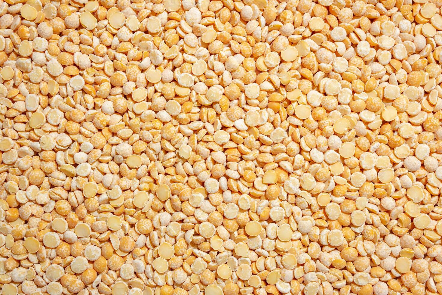 Uncooked Polished Split Peas Background. A Culinary Canvas of Dry Yellow Peas, Creating a Lively and Textured Background for Gourmet Cooking. Scattered Raw Polished Peas. Healthy Eating Ingredients photo