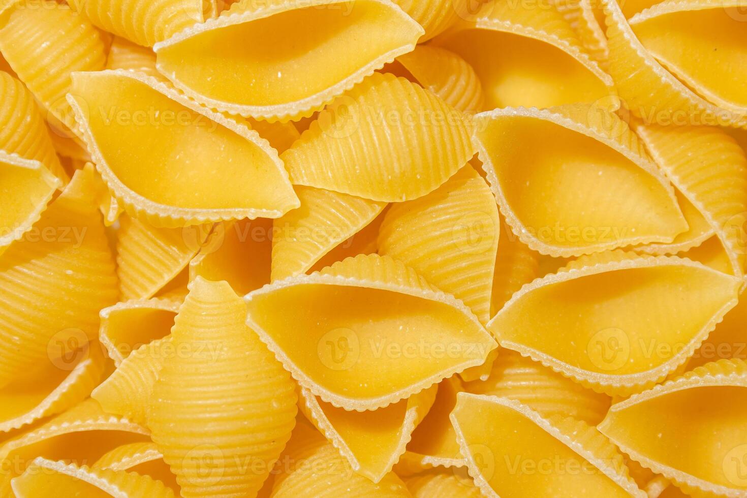 Uncooked Conchiglie Pasta. A Culinary Canvas of Conchiglie Macaroni, Creating a Lively and Textured Background for Gourmet Cooking. Dry Pasta. Raw Macaroni - Top View, Flat Lay photo