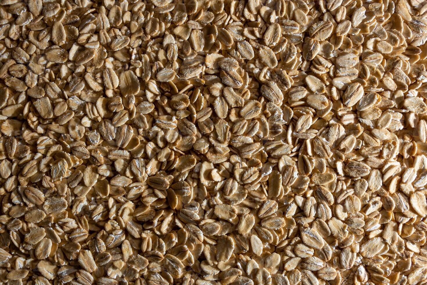Uncooked Oat Flakes background - Top View, Flat Lay. Scattered Dry and Raw Oat Flakes. Healthy Breakfast and Diet Eating Ingredients photo