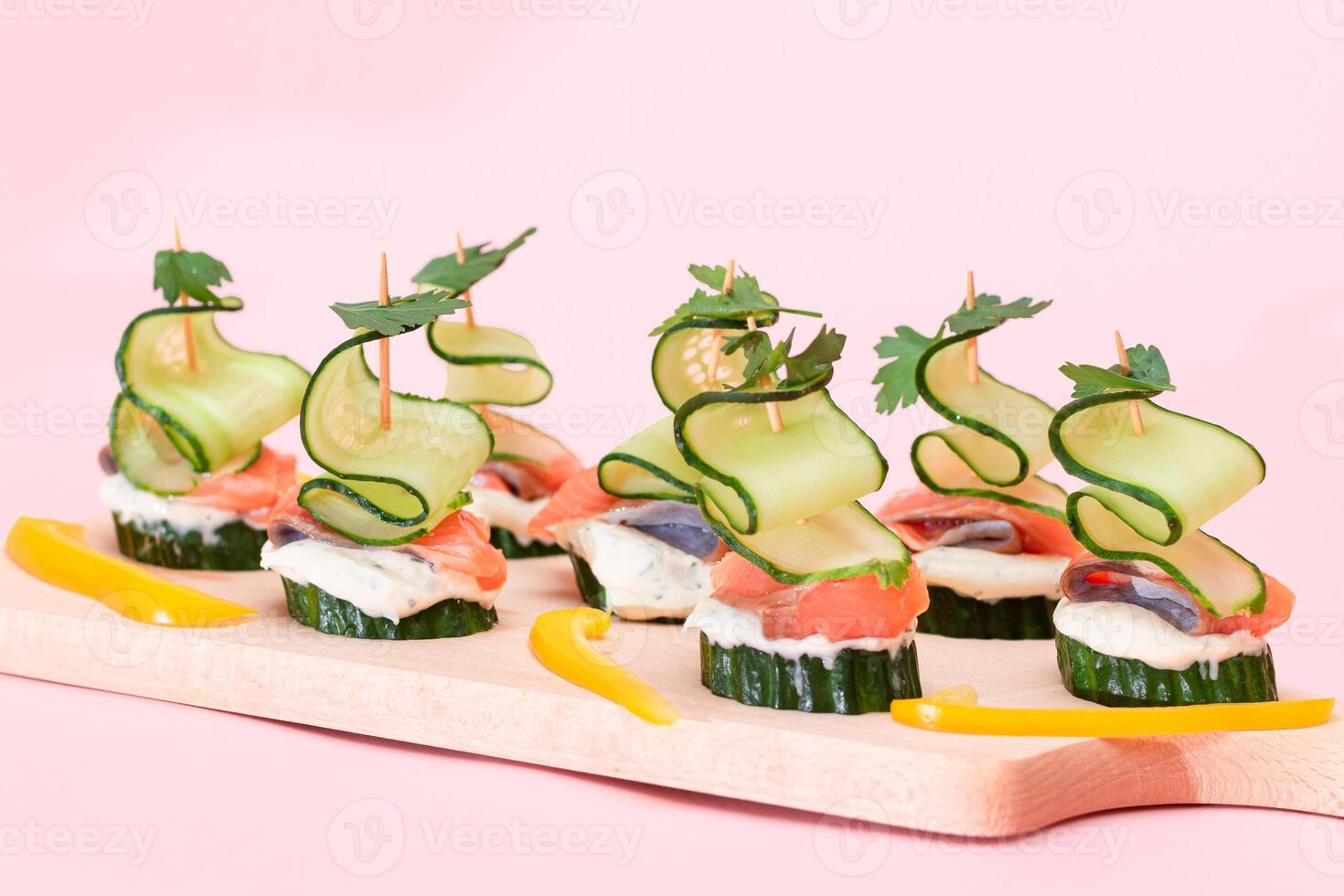 Canapes without Bread with Fresh Salmon, Cucumber and Cream Cheese on Wooden Cutting Board. Easy Breakfast. Diet Food. Quick and Healthy Sandwiches. Healthy Snacks with Tasty Fillings photo